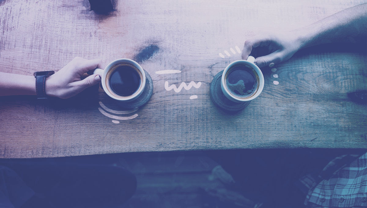 two friends holding coffee cups